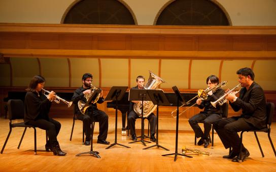 A brass quintet performs on stage