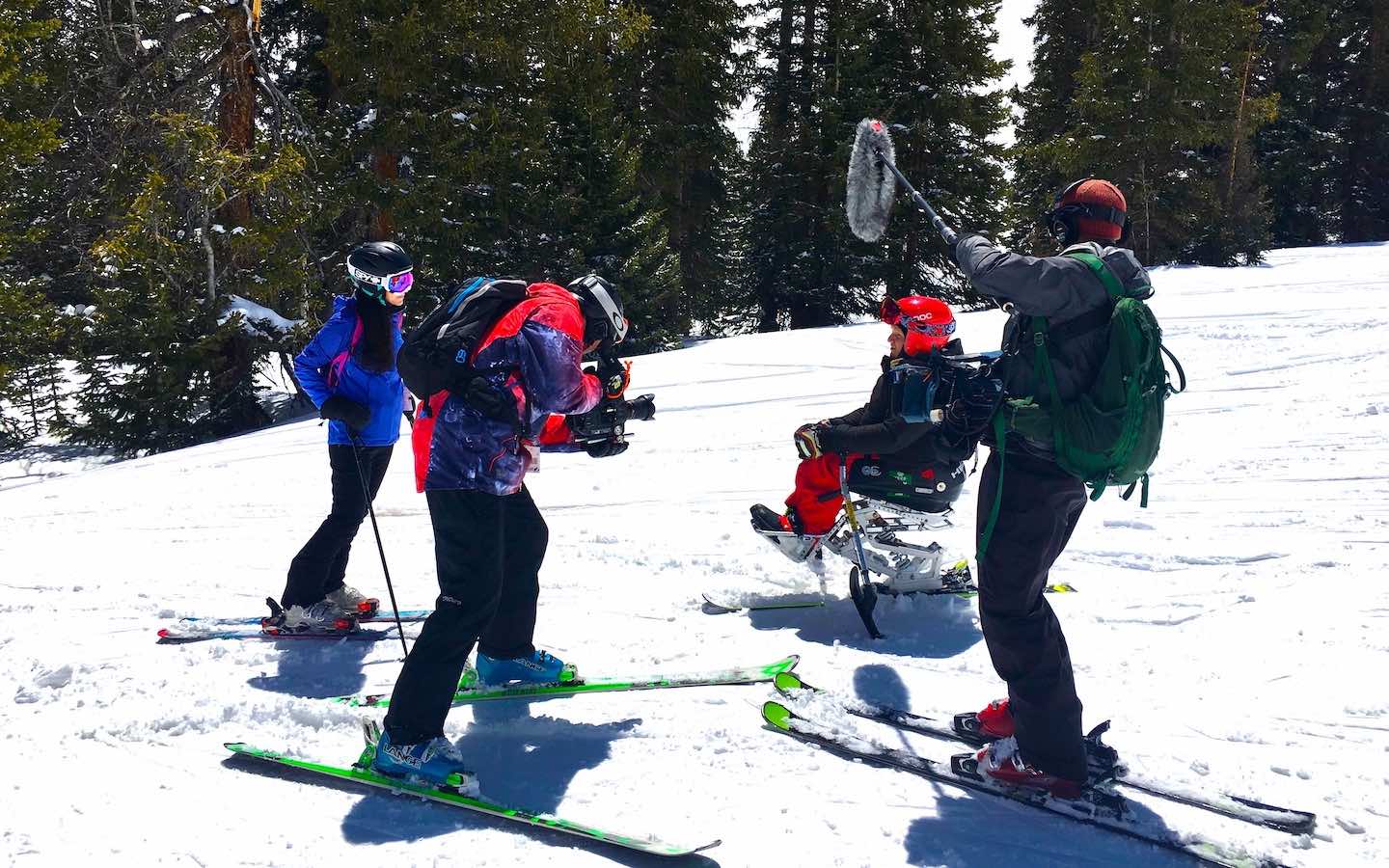 Creative writing alum Katie Liemkuehler filming an adaptive skiier