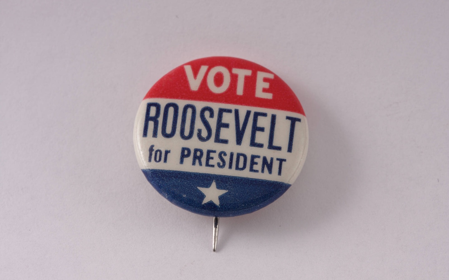 Red, white and blue pin with the words "Vote Roosevelt for President
