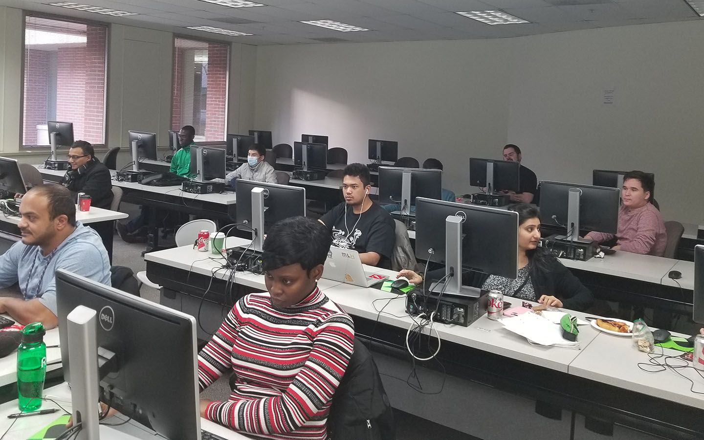 Cyberz club members participating in cyber competition sitting behind computer screens in a classroom setting..