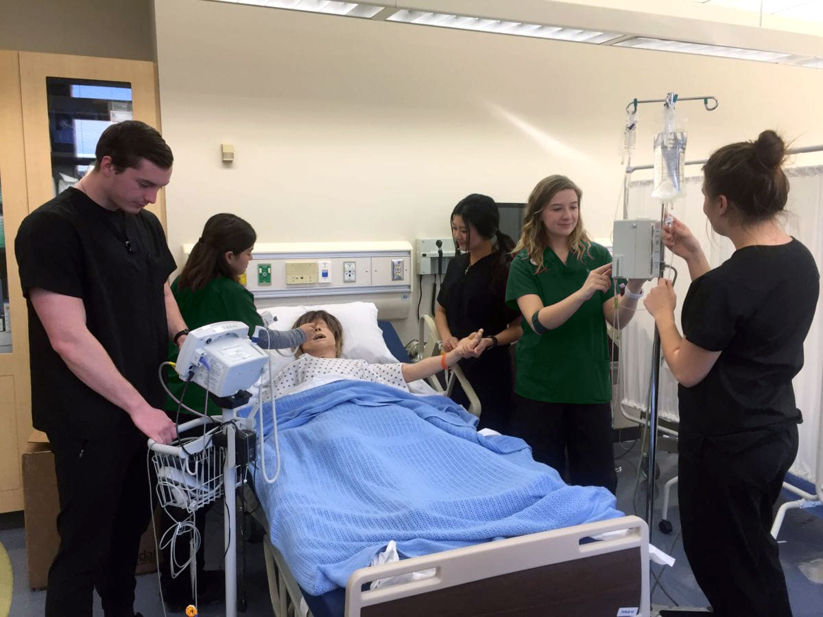 Nursing students performing lab work in a hospital setting.