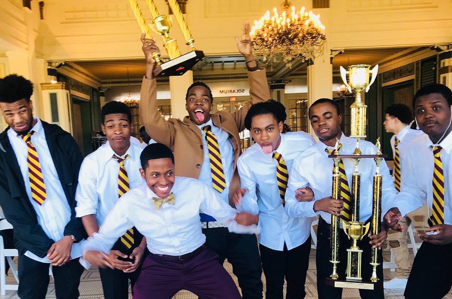 Roosevelt University alum Marlon Haywood and six mentees, waving trophies