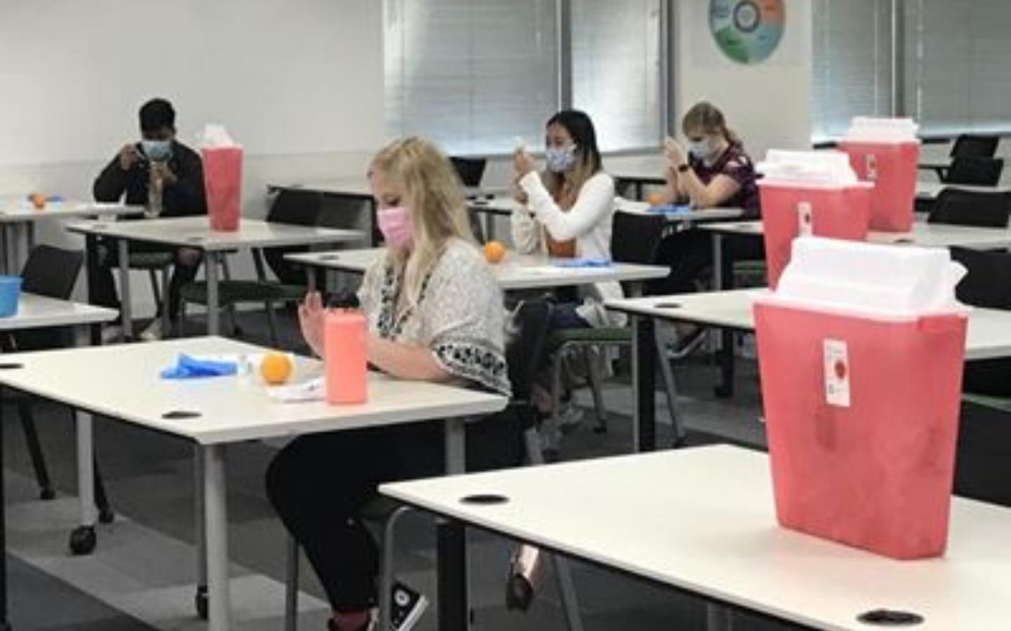 Students socially distanced with masks participating in labs