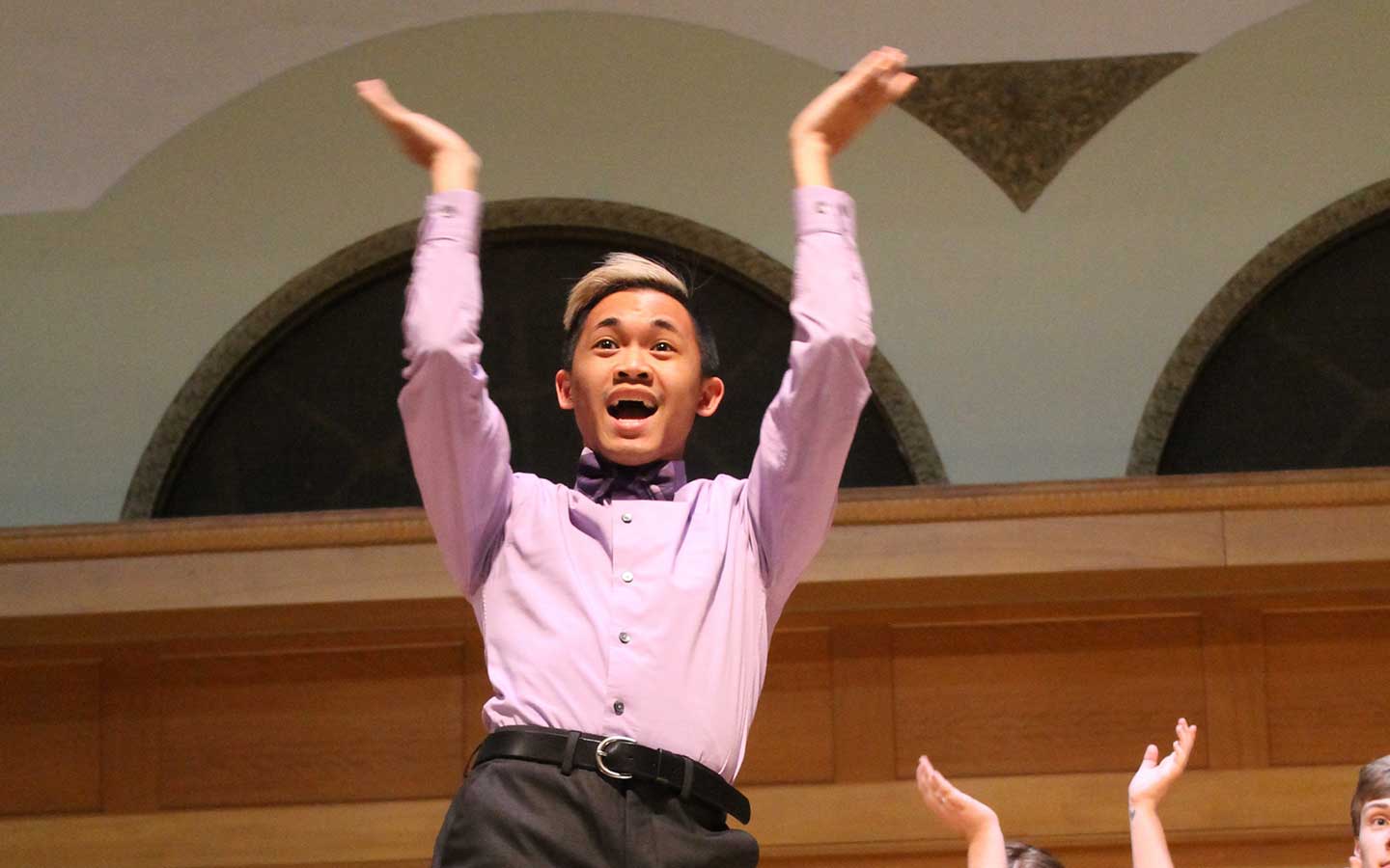 a vocal student singing and clapping