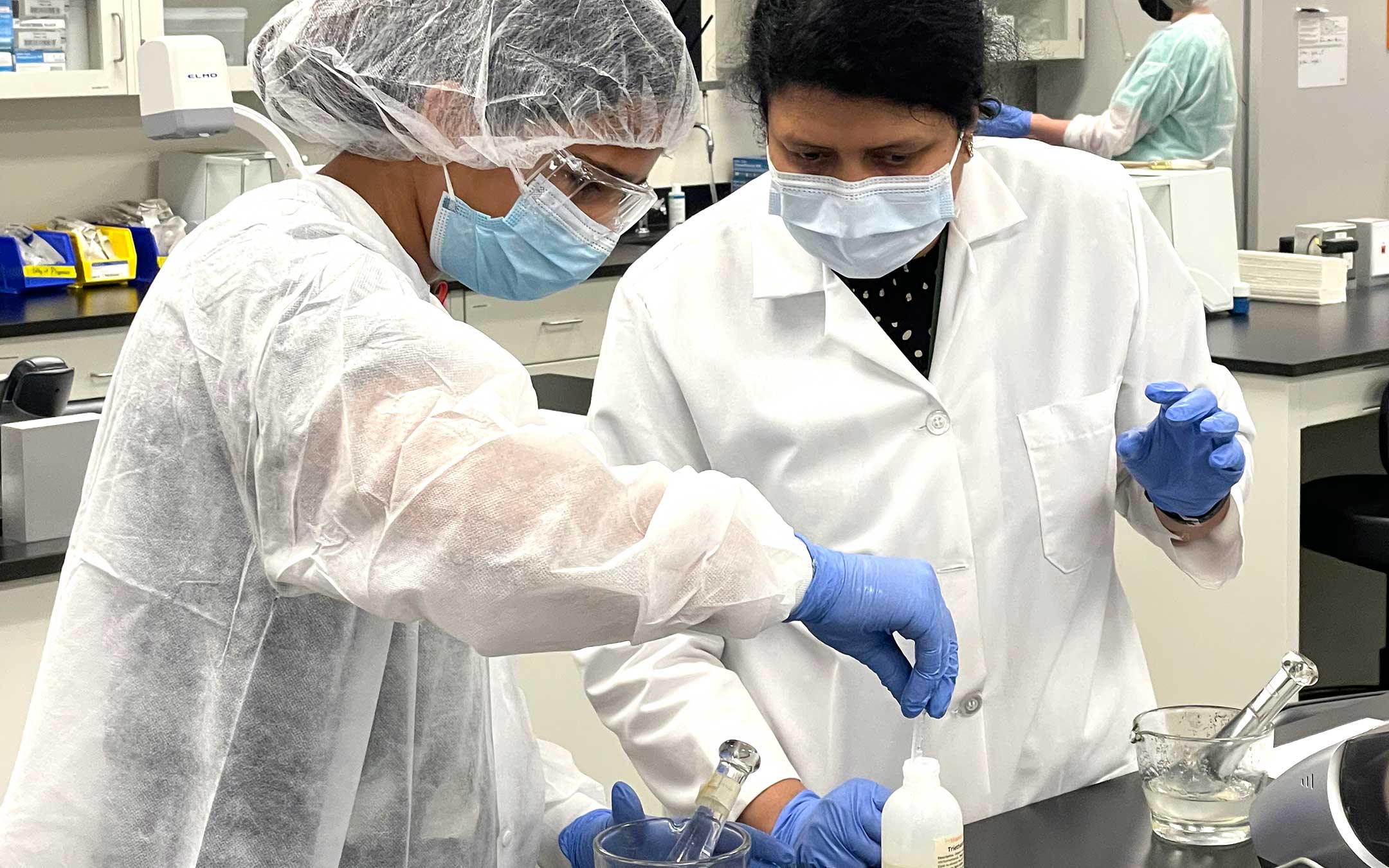 A member of the Summer Pharmacy Academy learns about compounding from an instructor