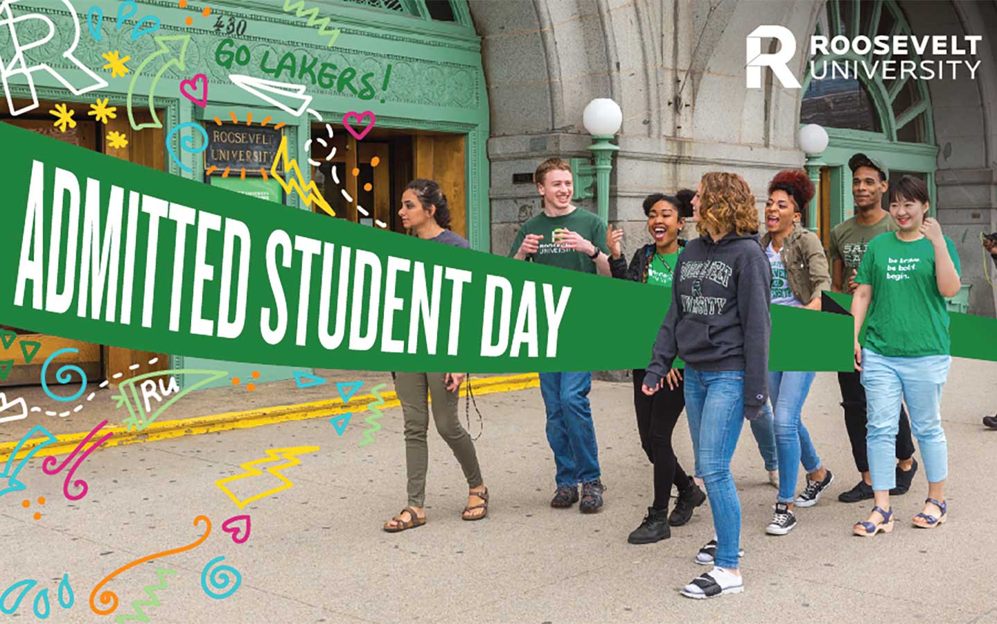 Students walking in front of the Auditorium Building, with a banner reading "Admitted Students Day"