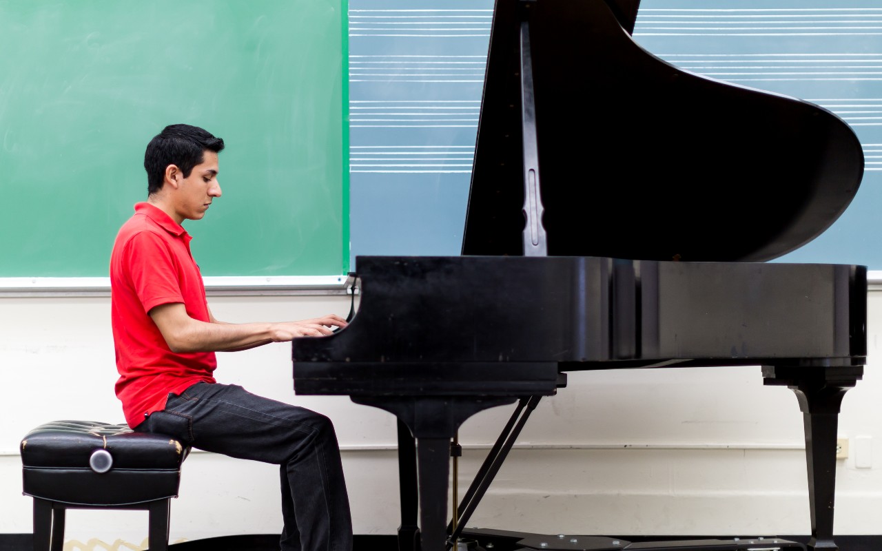 Student in red shirt playing piano