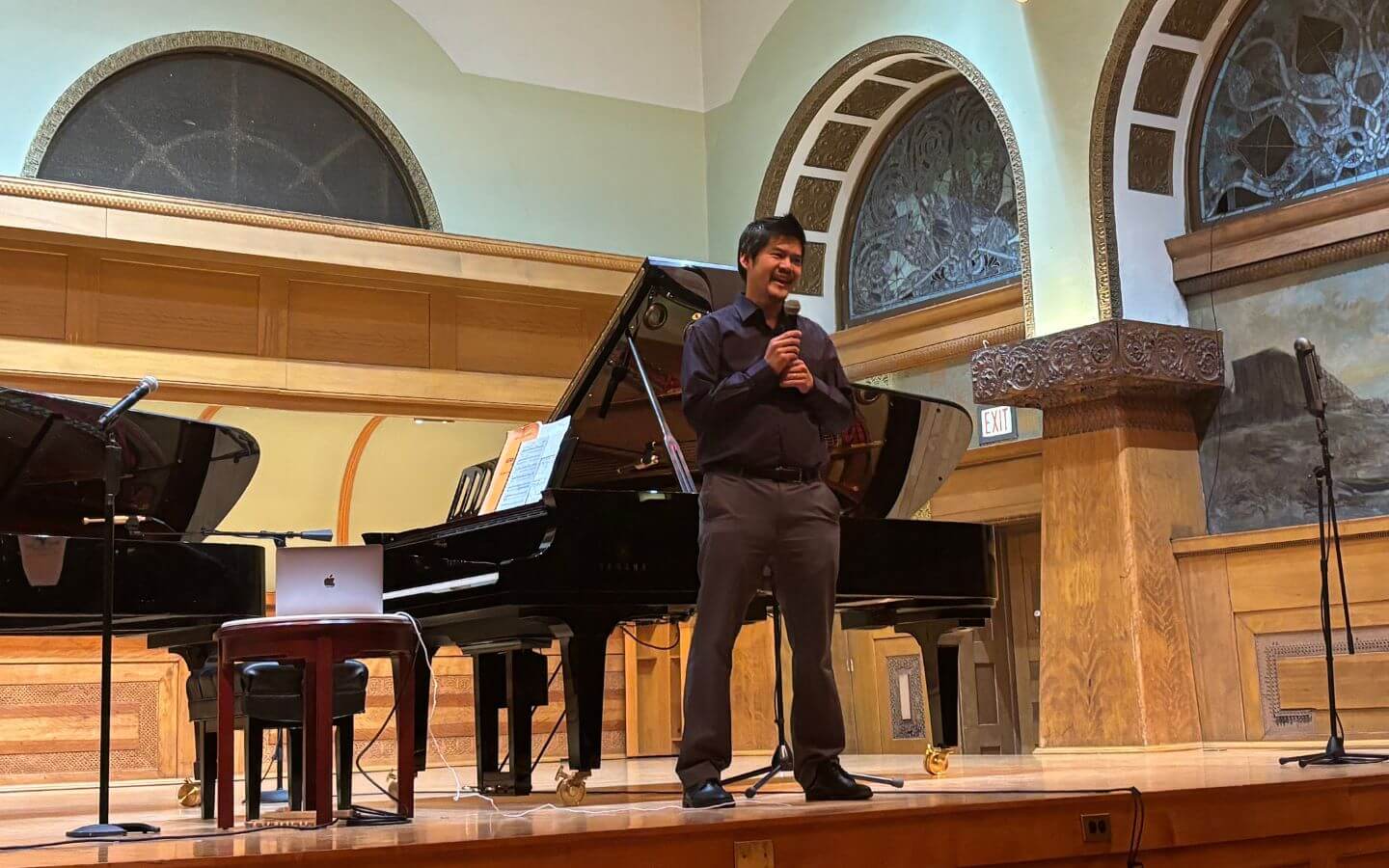 Winston Choi standing on stage introducing the piano sessions for the first phase of the International Piano Competition of Orléans