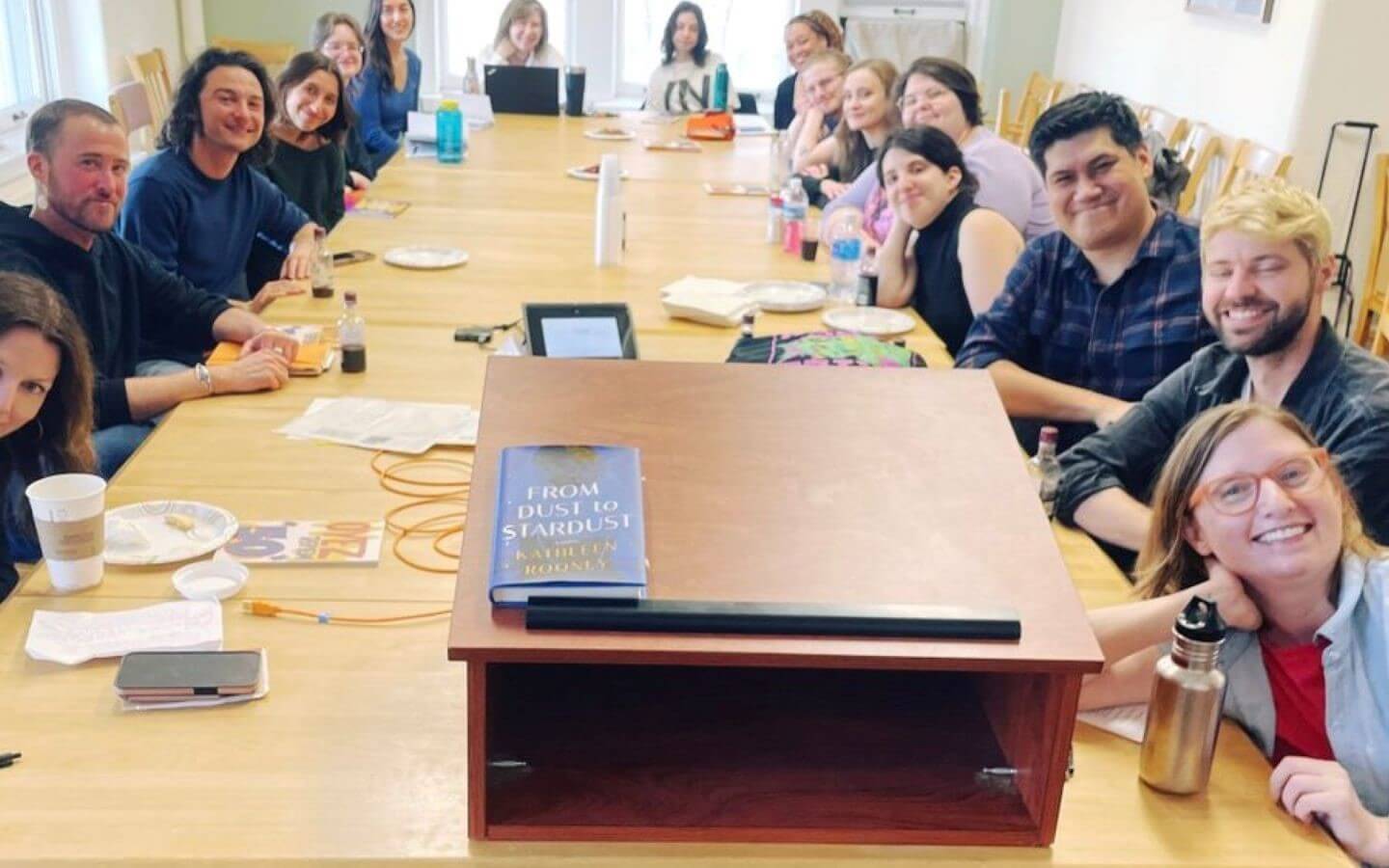 Creative writing group sitting around a table to discuss Rooney and Scanlon's works.