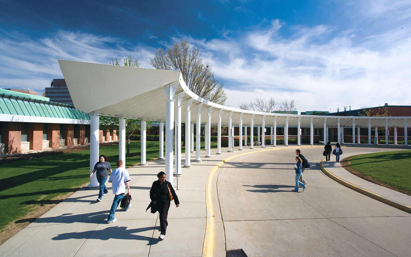 Students walking outside the Schaumburg campus, with blue sky and white clouds in the background