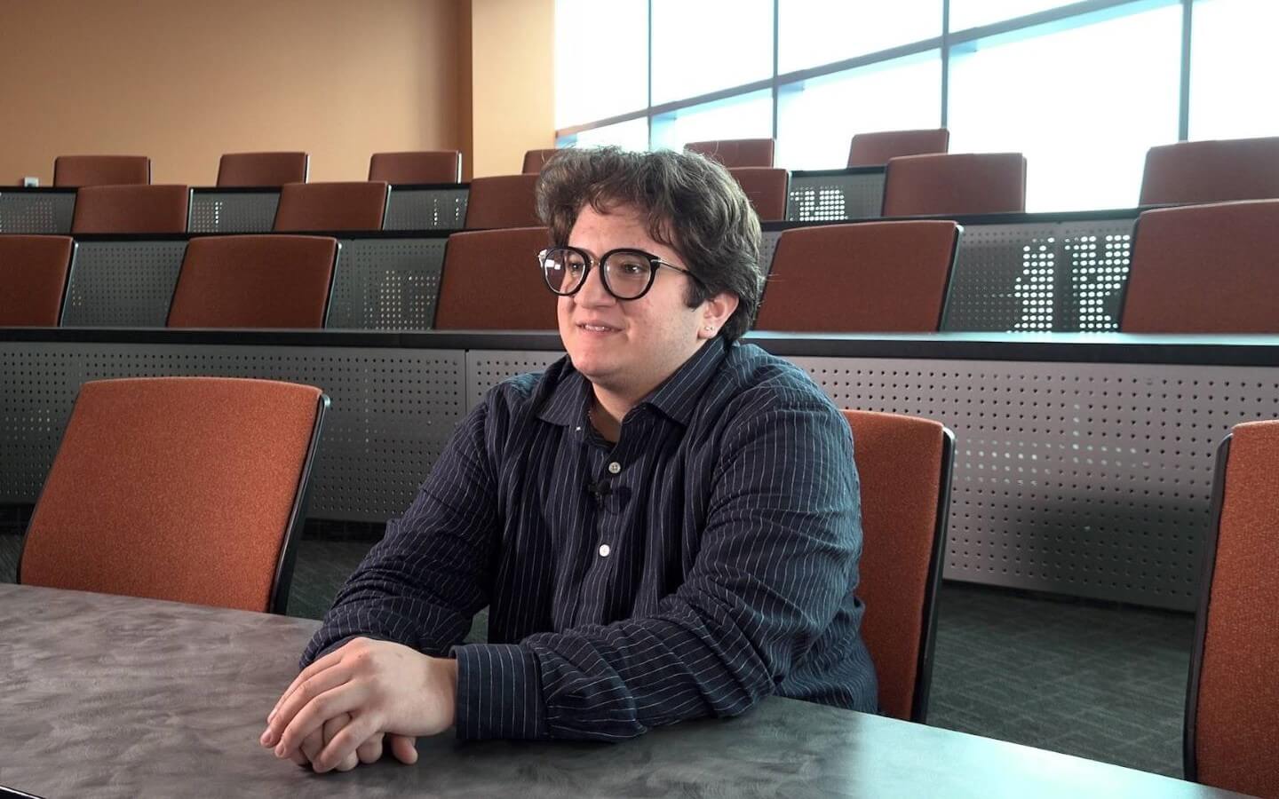 President of RU Proud, Michael Scarpelli, sitting in at table in the Wabash classroom at the Chicago campus.