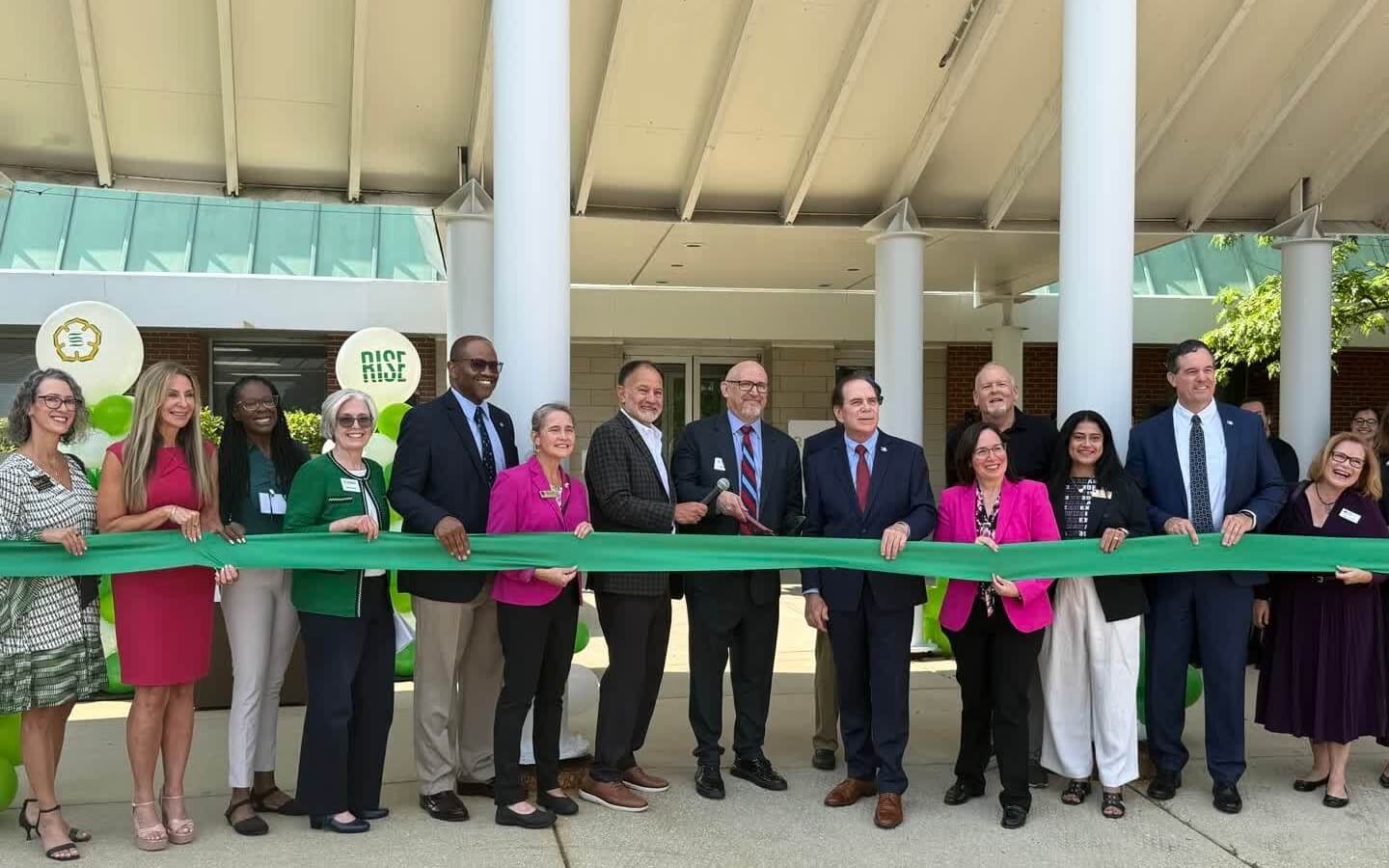 RISE Ribbon Cutting at Schaumburg Campus with several people standing behind a green ribbon