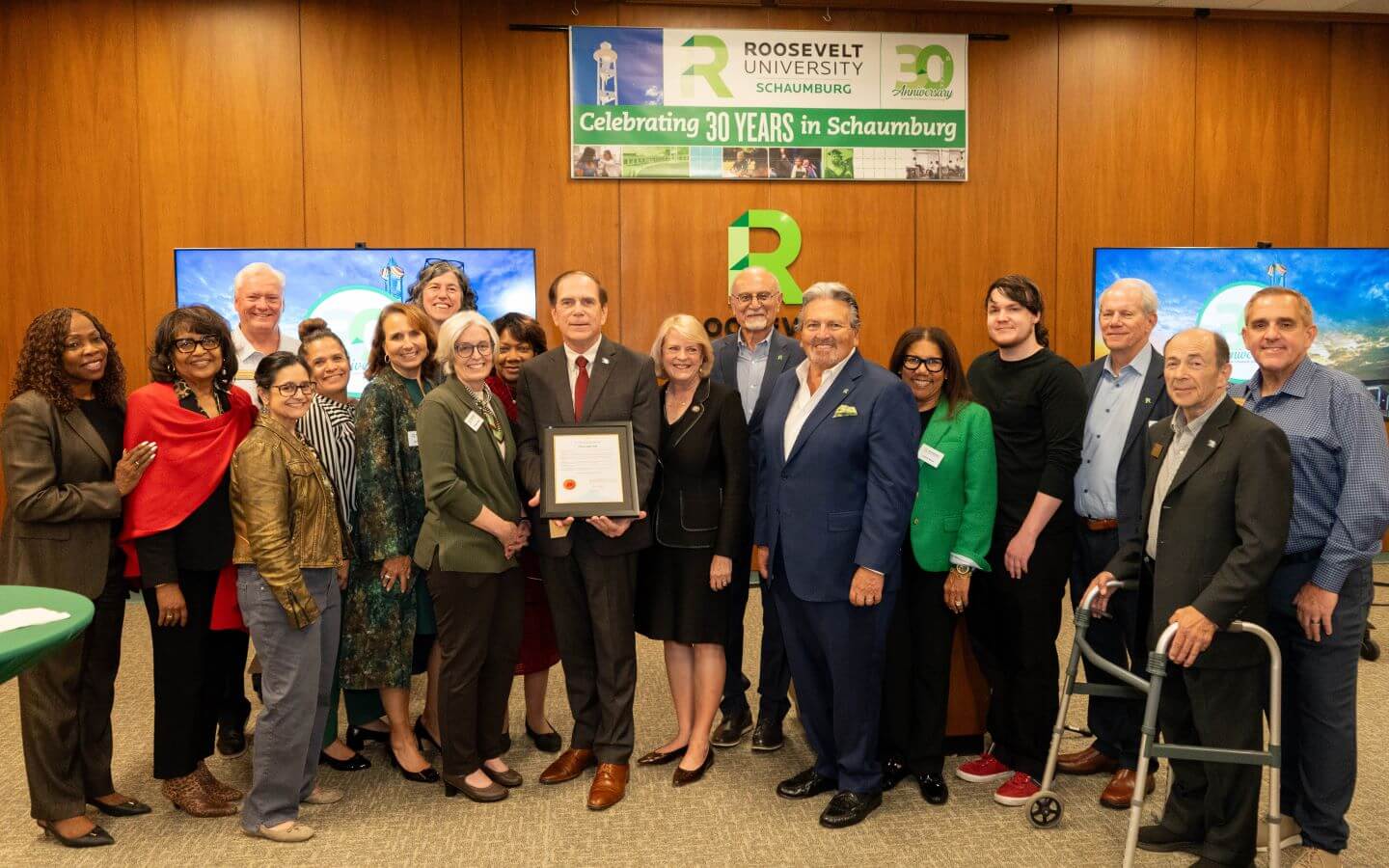 RU Board of Trustee Members, Staff, Faculty and Community Partners gather with a plaque to acknowledge the 30 year anniversary of the Schaumburg campus