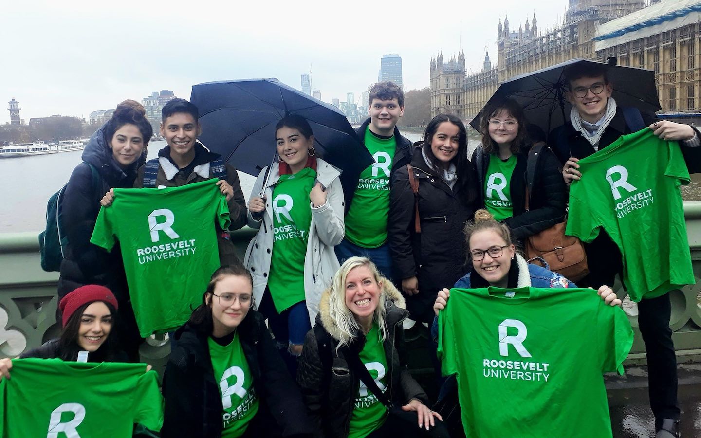 Ten students holding green Roosevelt t-shirts in front of the Palace of Westminster.