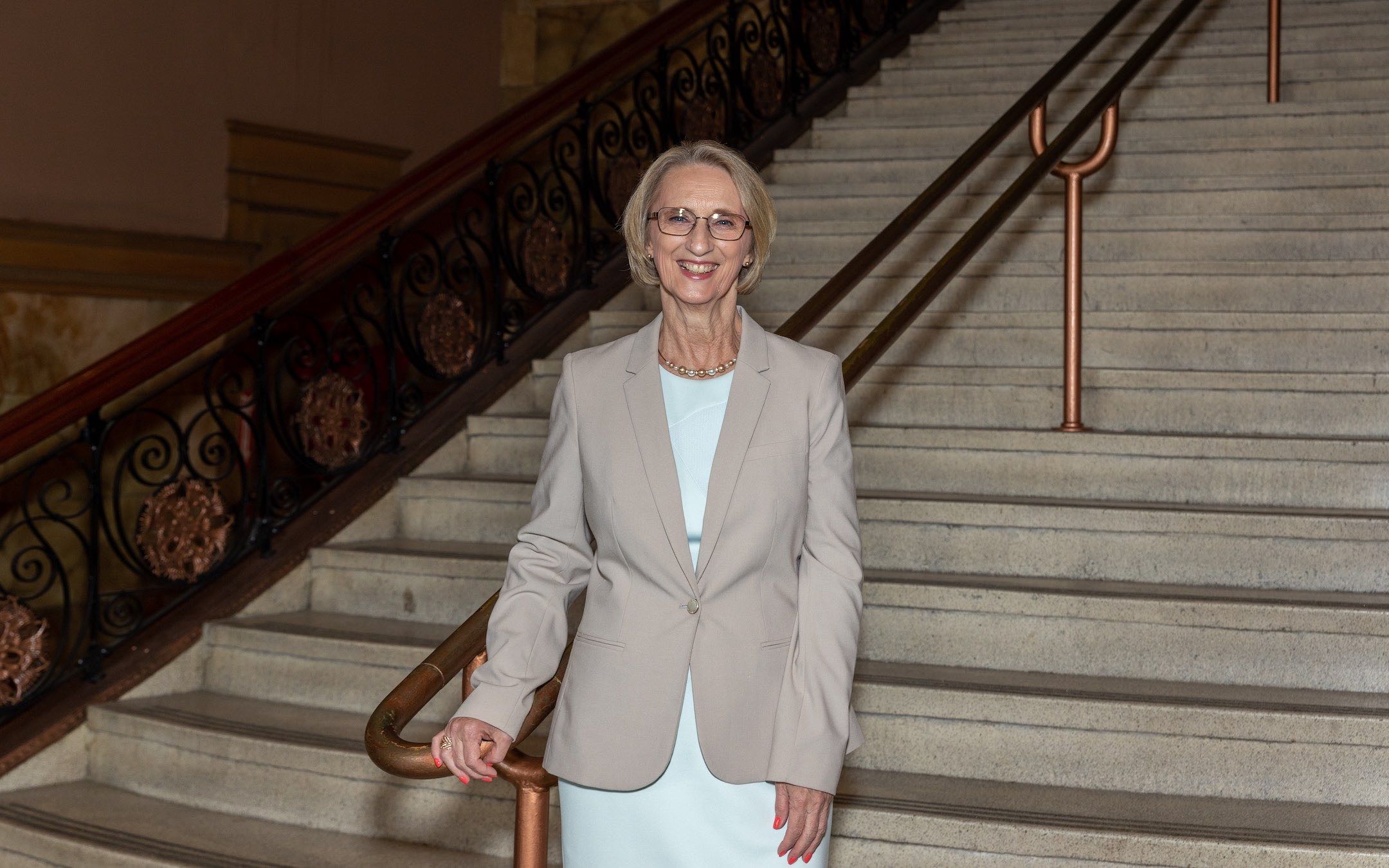 Mablene Krueger, chief operating officer of the Schaumburg Campus, standing in the grand stairs of the Auditorium Building