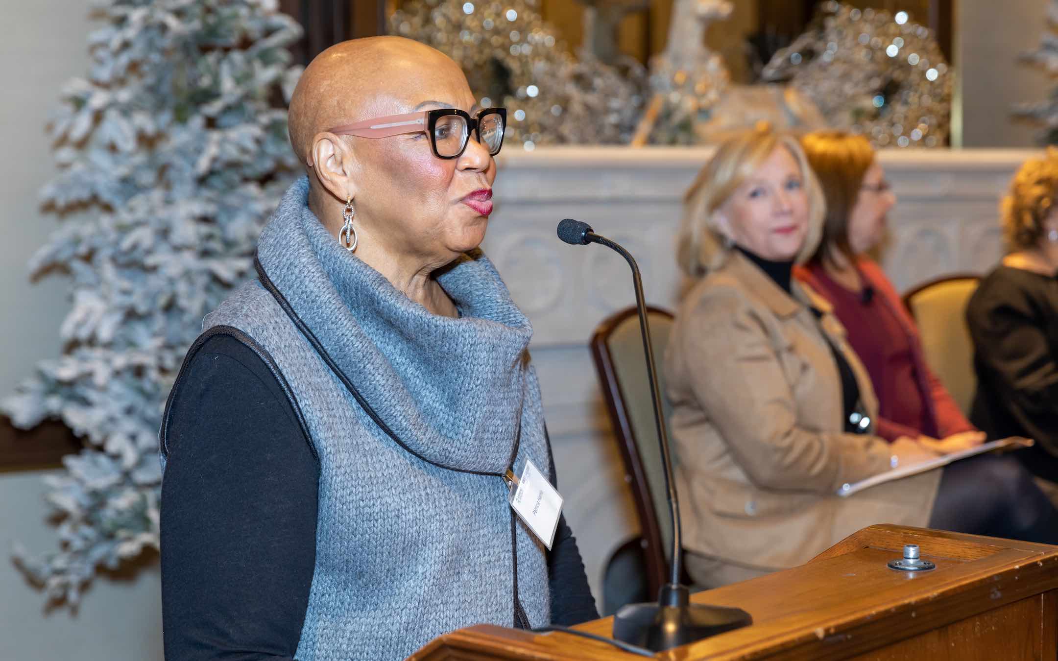 Pat Harris, Roosevelt's Board of Trustees chair, introducing guest speakers from a podium