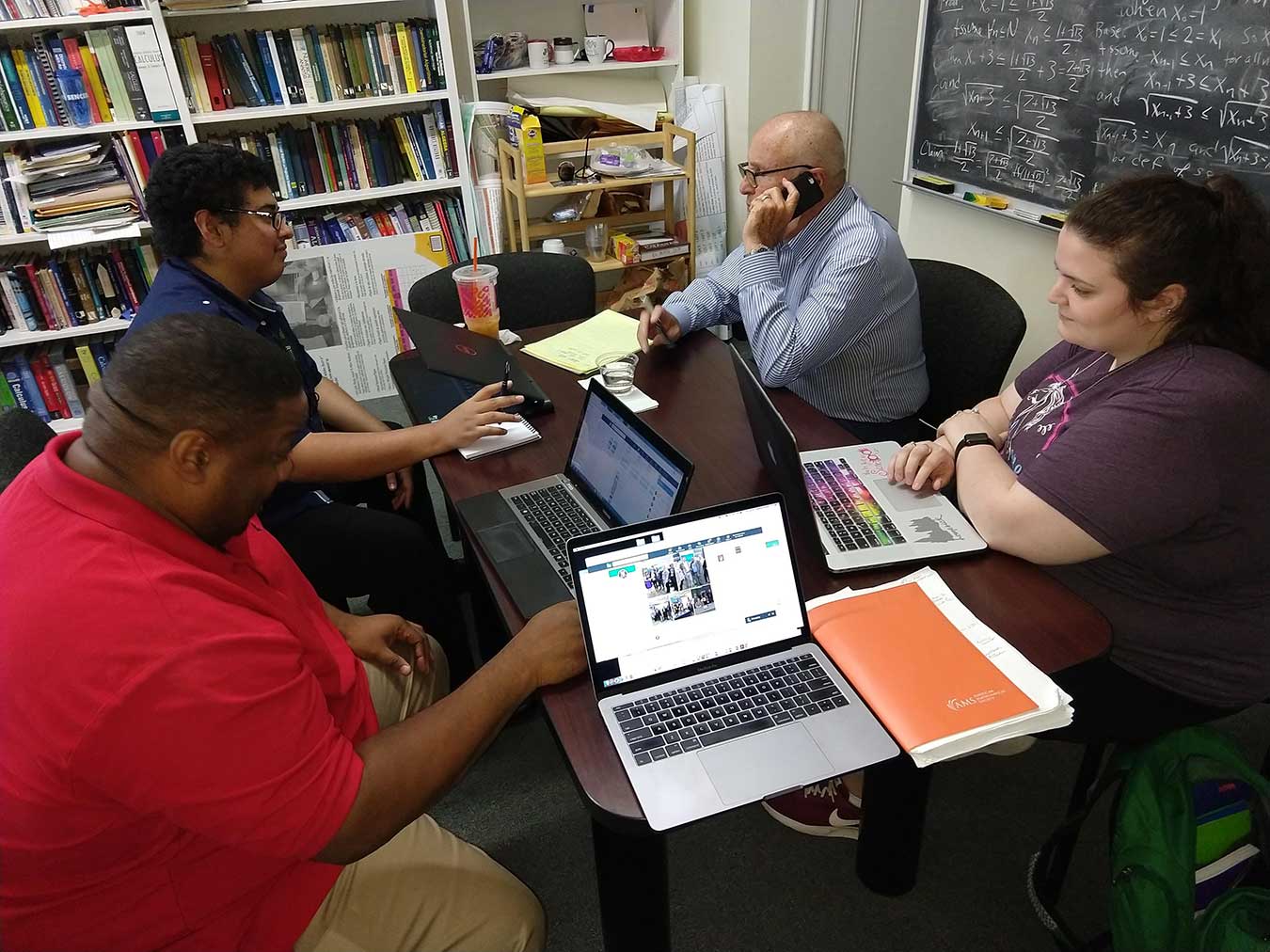 students and faculty around a table