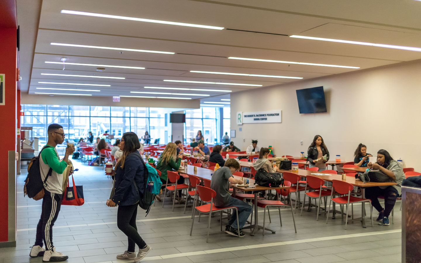View of the dining center featuring students at number of tables and chairs.