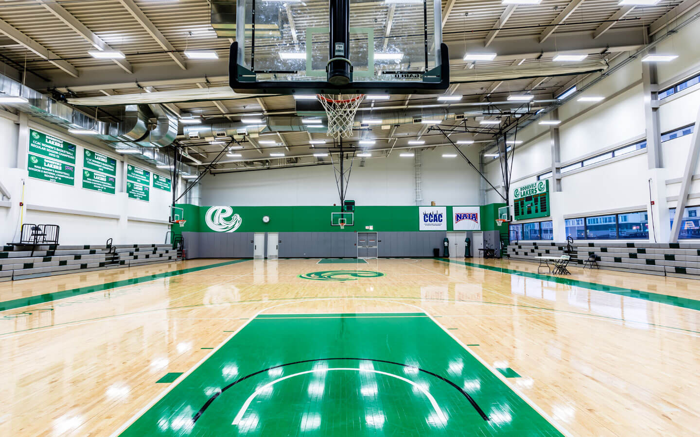 A view of the Goodman Center basketball court with green Roosevelt colors featured on the walls and floor.