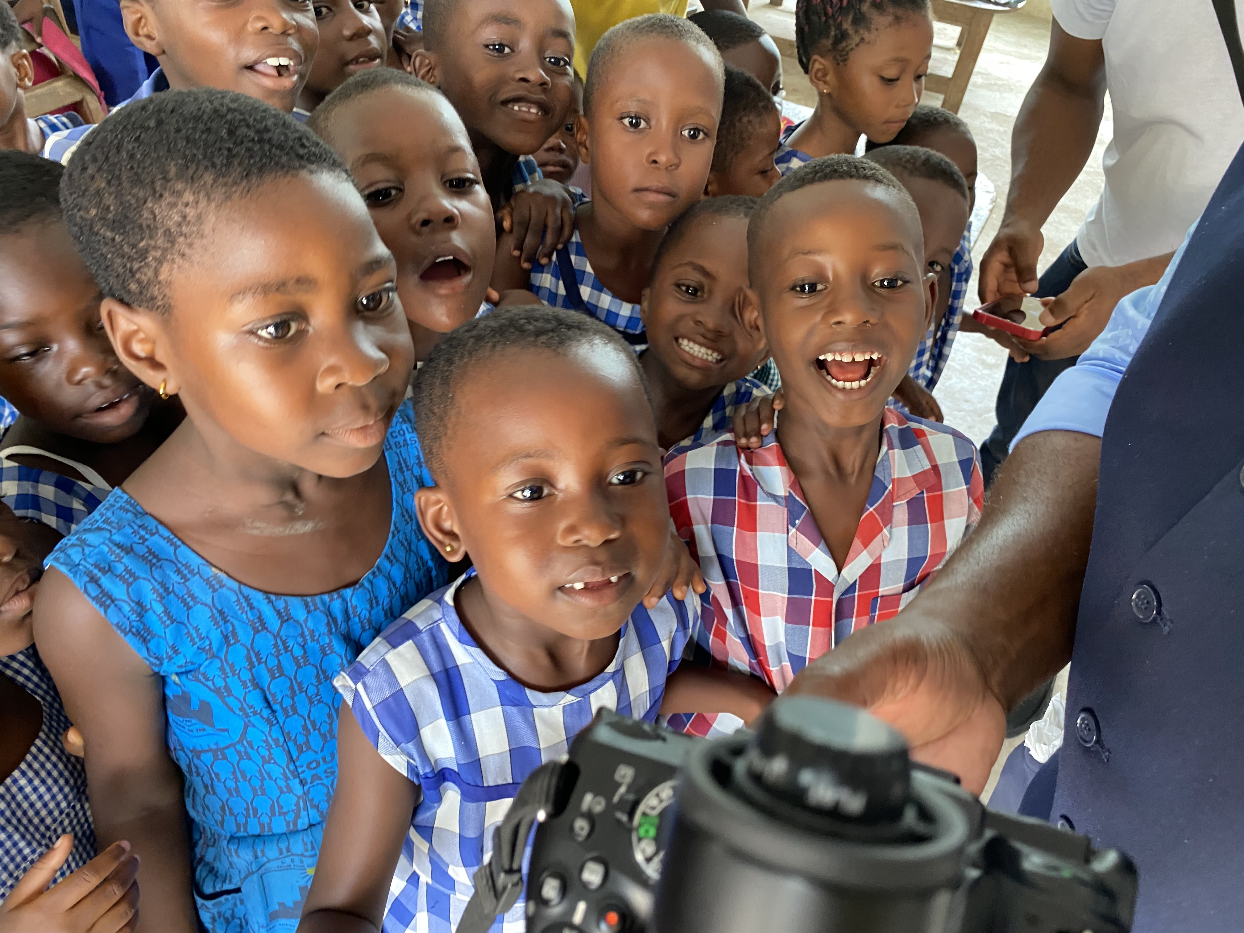 Professor Fountain shows children during his time as a Fulbright Scholar in Ghana their photos.
