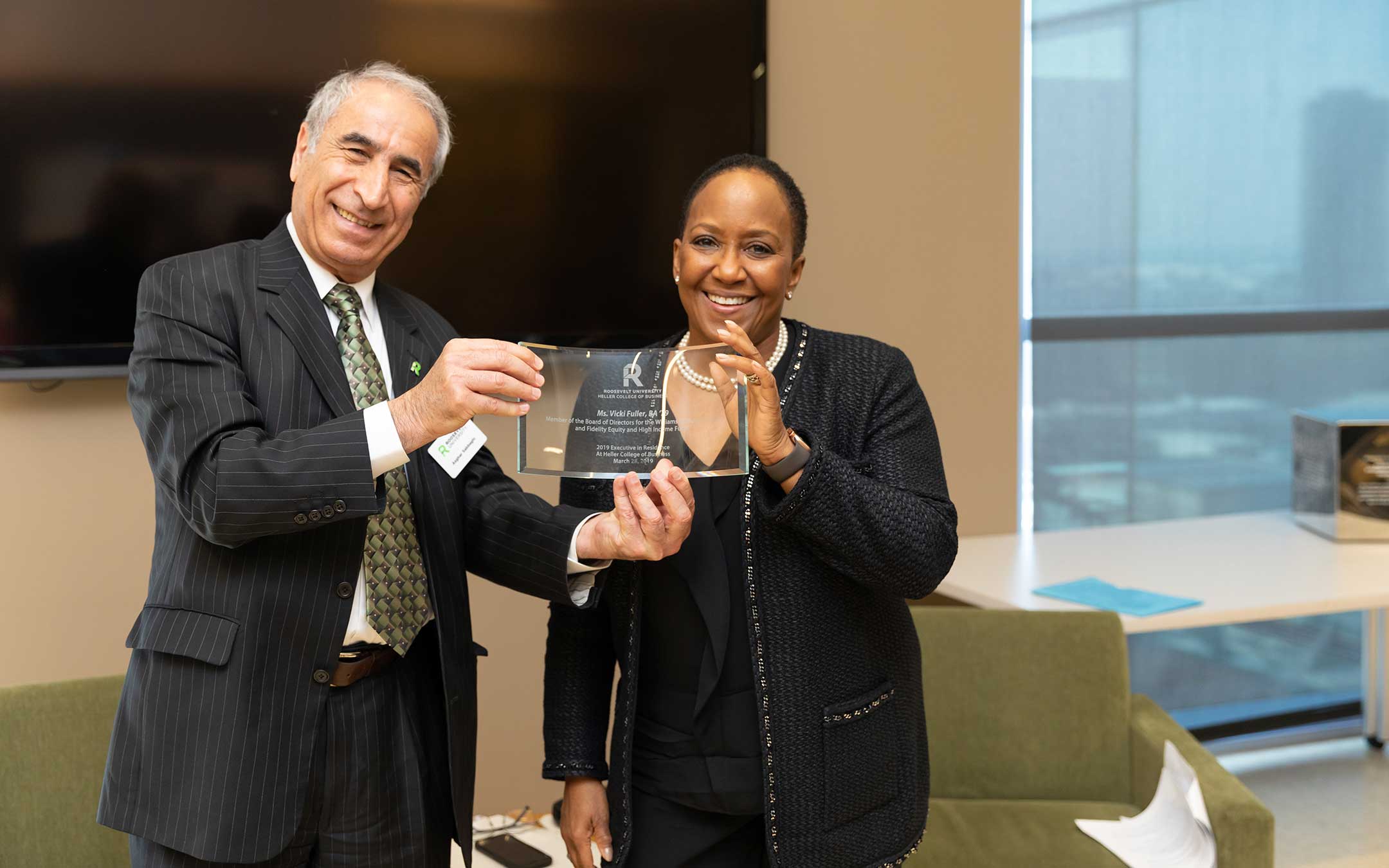 Heller College of Business Dean Asghar Sabbaghi presents an award to Roosevelt University's 2019 Executive-in-Residence Vicki Fuller