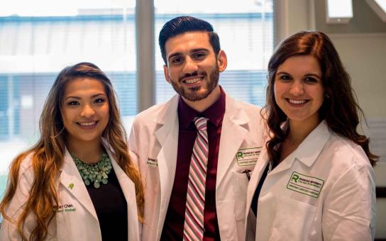 Three Pharmacy students in lab coats