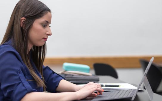 Student types on her laptop in a Roosevelt classroom