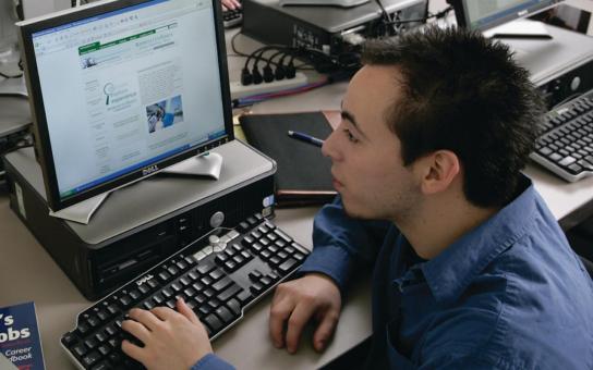 Male student job searching on the computer