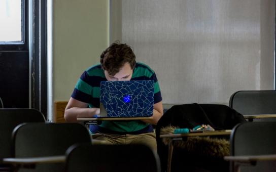Student intensely studying and working on laptop