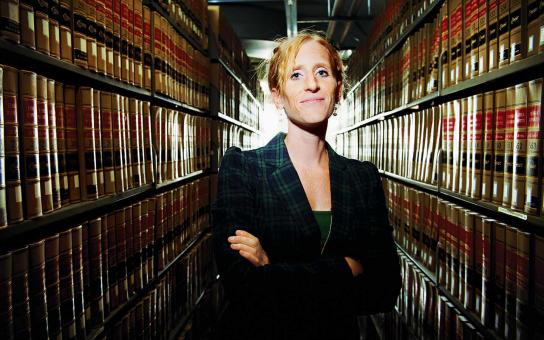Samantha Heinritz stands between two rows of law books