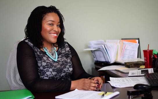 Smiling person sitting at office desk