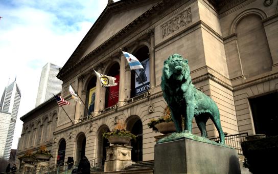 Main entrance of the Art Institute of Chicago featuring the iconic lion statue and partial skyline