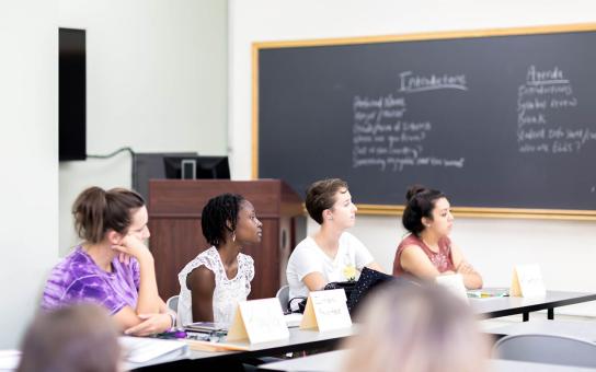 A panel of students listening to someone speak