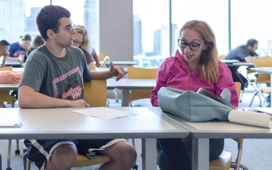 Two students in discussion during a break-out session in a Wabash Building classroom.