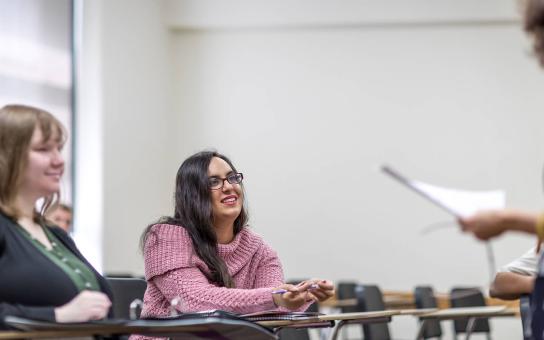 A student is intently listening to an instructor explaining something