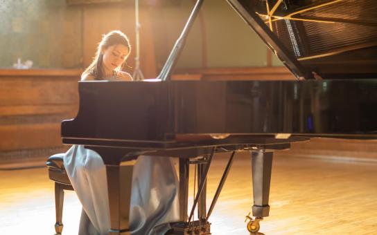 Pianist performing on a grand piano in Ganz Hall