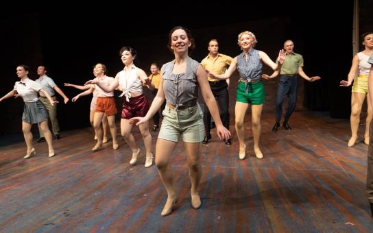 Performers in costume dancing on stage.