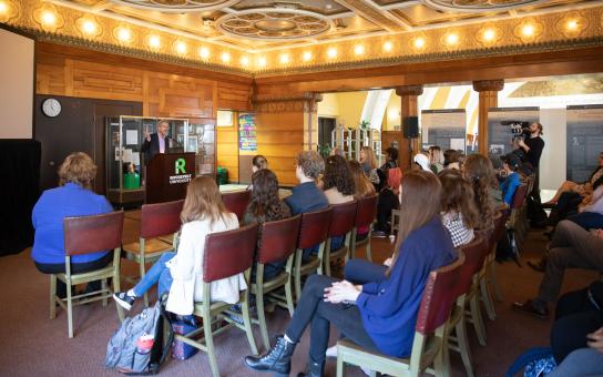 Speaker presenting in front of an audience inside the Auditorium Library.