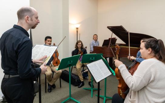 Instructor leading a small group of students in a strings practice