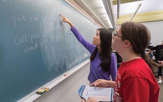 Faculty and Student working at a classroom blackboard