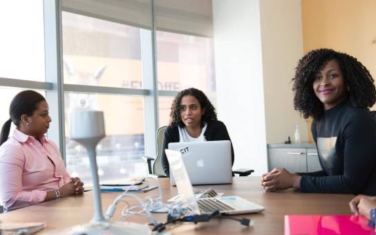 Multiple people in discussion around a table in a conference room