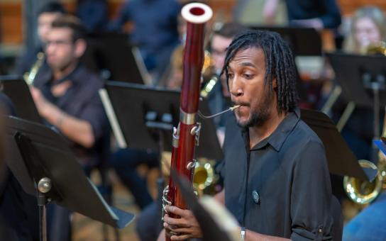 Bassoonist performing while reading music.