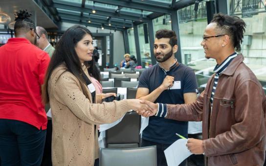 Two people introducing themselves to each other with a handshake.