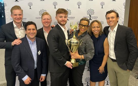 a group of Roosevelt students stand with their trophy for first place in the graduate division of the Harold E. Eisenberg Foundation Real Estate Challenge