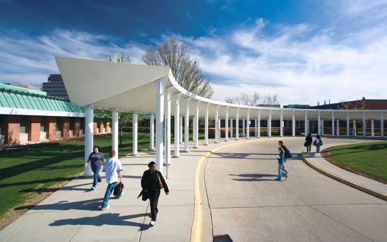 Students walking outside the Schaumburg campus, with blue sky and white clouds in the background