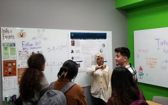 Students discussing the contents of a whiteboard in the STEM Center