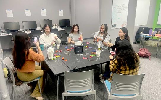 Students completing crafts during an event at a table in the STEM Center