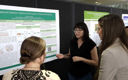 McNair scholar presenting their research to two faculty members