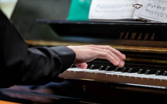 Close-up of hands playing a piano
