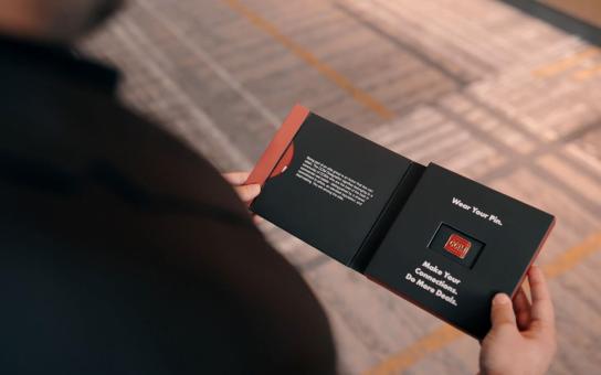 Person holding a booklet with a Certified Commercial Investment Member designation pin.
